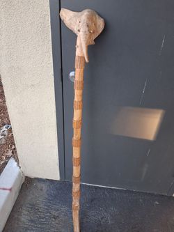 Cane, hand-carved wood elephant head handle paired with a rustic, segmented shaft.