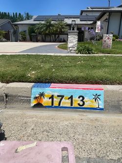Curb painting with American flag top and beach scene background