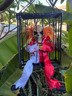 Animated Halloween skeletons in cages with motion, voice and red eyes about 15 inches tall