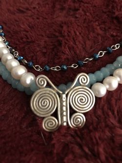 Hill tribe silver butterfly pendant on a necklace made of pearls and aquamarine beads