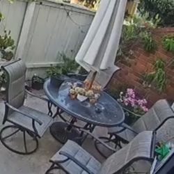 Patio Furniture Set - Outdoor table with umbrella and four chairs.