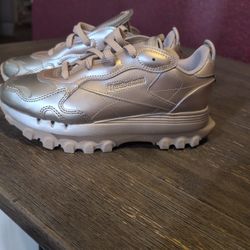The Reebok Cardi B women's Classic Leather in Silver Metallic Pewter (model GW2632) features a metallic upper inspired by New York City's skyline at n