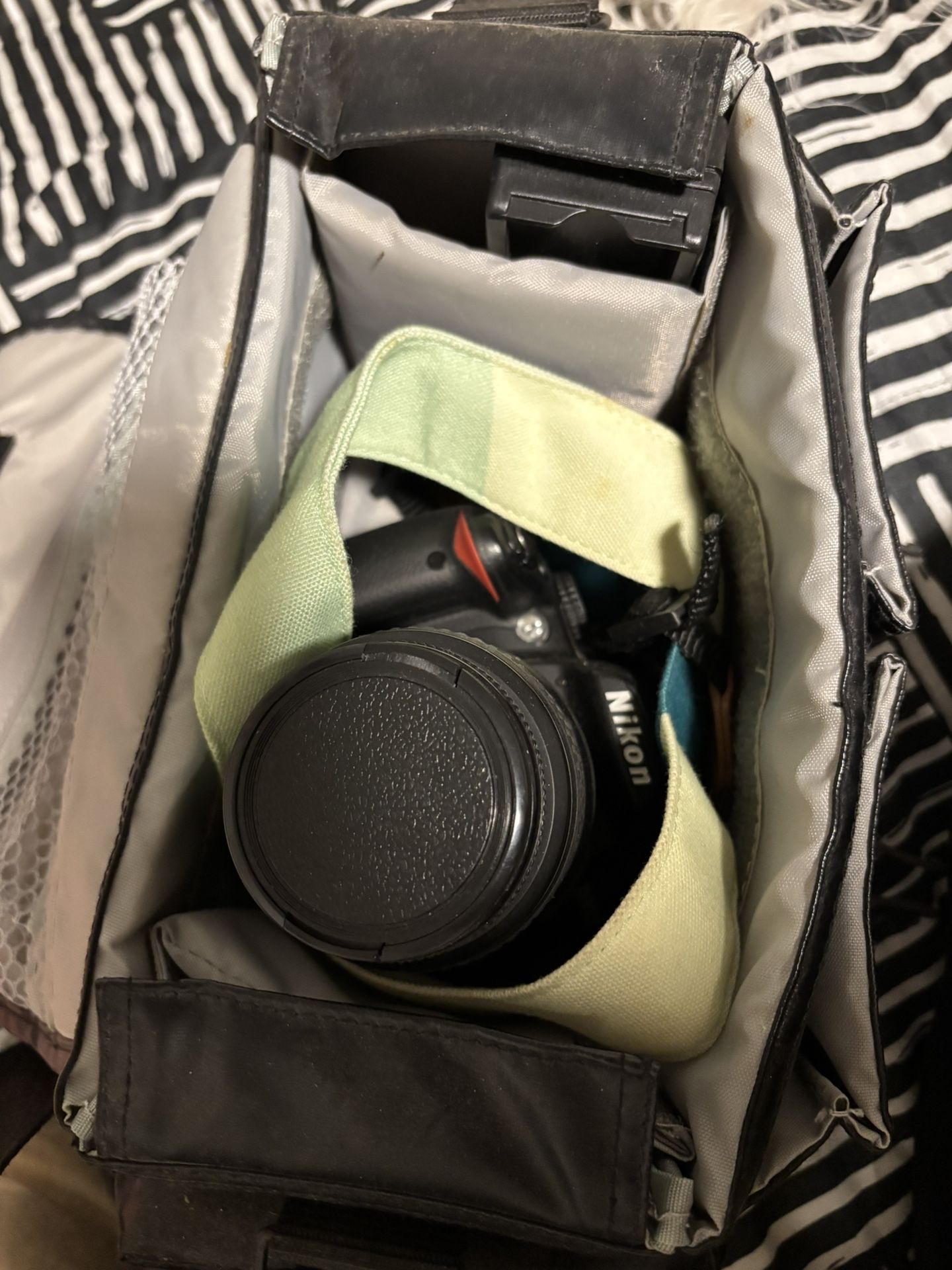The Nikon D3000 camera includes an original strap and an adapter to transfer photos to your phone.