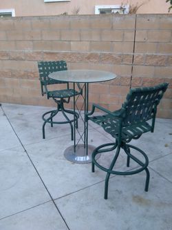 Glass table with two swinging stools