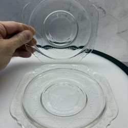 Set of (2) Vintage Federal Glass Madrid pattern clear depression glass saucers from the 1930s featuring intricate embossed scrollwork and scalloped ed