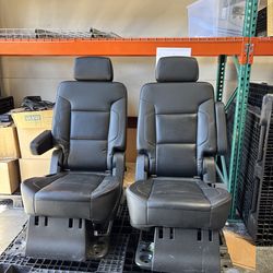 Stylish black car seats, a pair. Has comfy armrests and adjustable headrests. Made from a durable leather-like material with neat white stitching. Sea