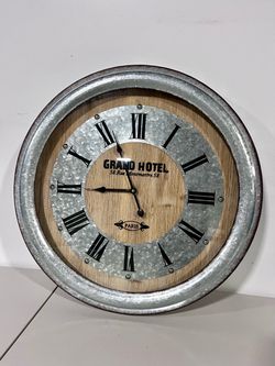 Wall clock vintage style wooden center, a galvanized metal face with black Roman numerals, and the text "GRAND HOTEL 58