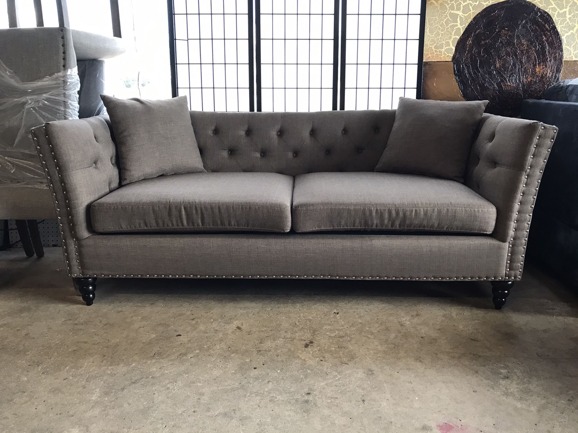 Brown tufted sofa with nailhead trim