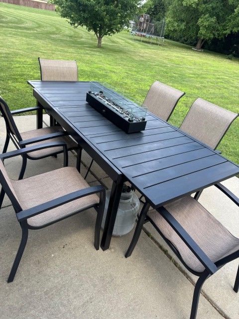 patio table with 6 chairs and gas tank heater.