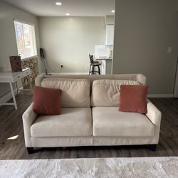 Cream suede couch with coral pillows