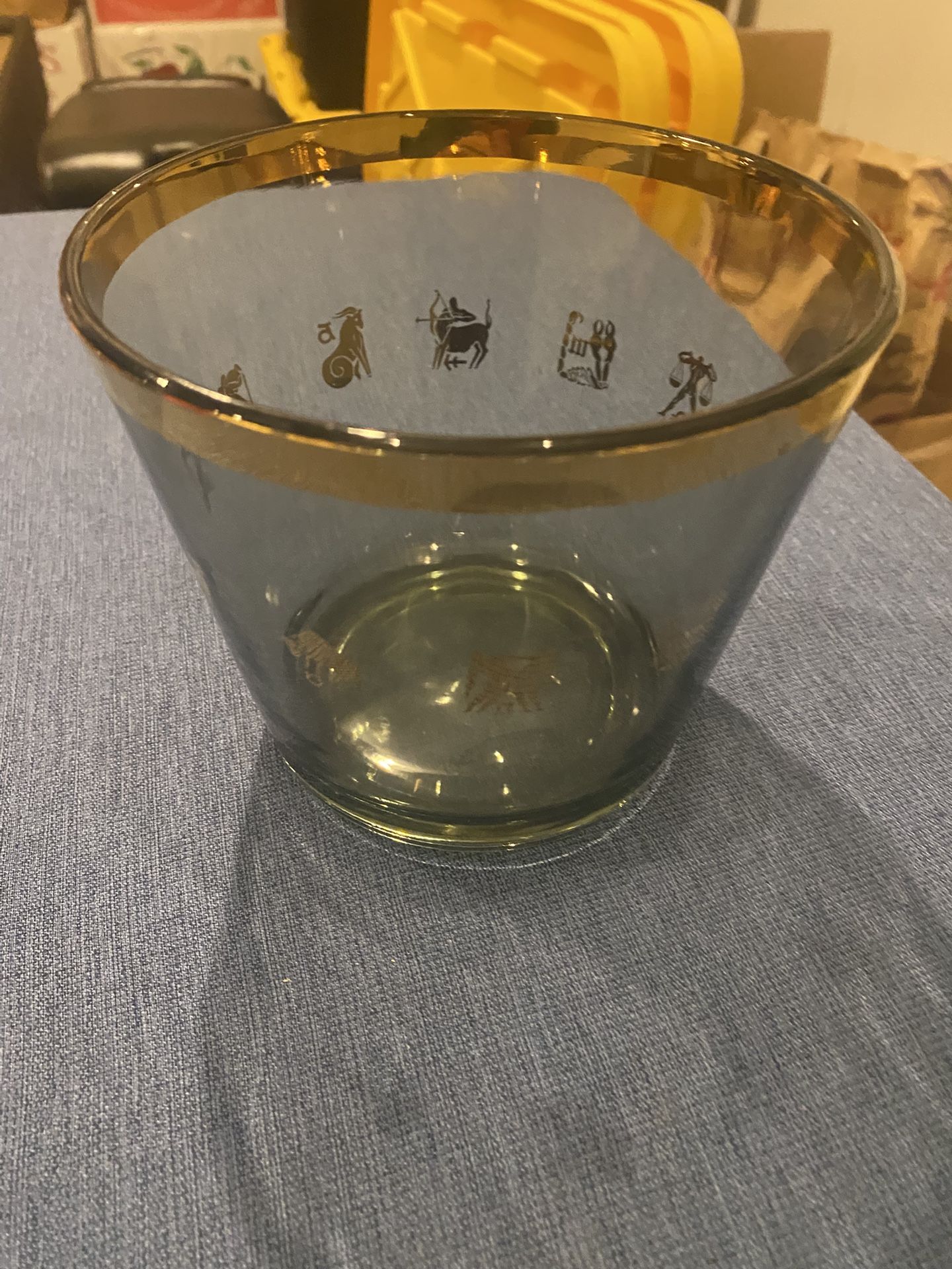 Vintage glass ice bucket with gold trim, and various zodiac sign illustration