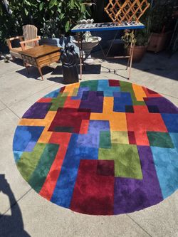 Round rug presents a colorful geometric design of color blocks from the New Wave collection by Momeni.