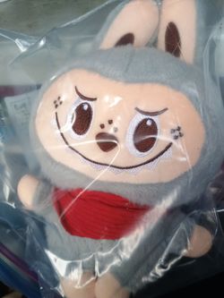 grey Labubu monster plush toy wearing a red scarf