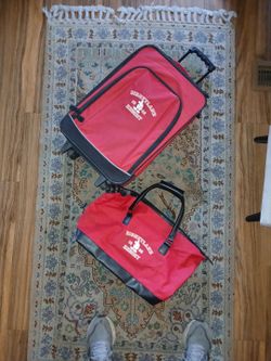 Official Disneyland  Resort red rolling carry-on suitcase and handbag.