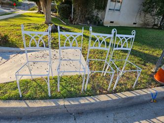 matching set of four white wrought iron patio chairs