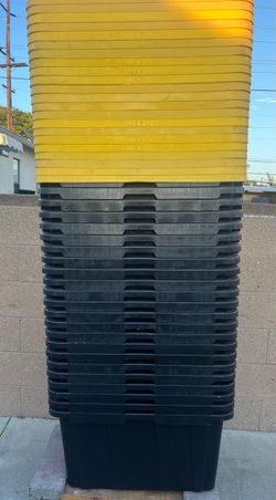 23 black storage totes and 23 yellow lids  27 gallons  each
