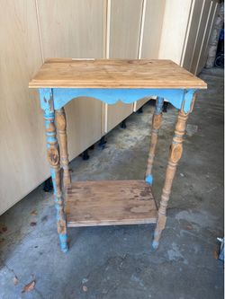 Distressed wooden side table with spindle legs and a light blue paint finish.