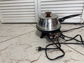 Vintage Oster electric fondue pot made of stainless steel.