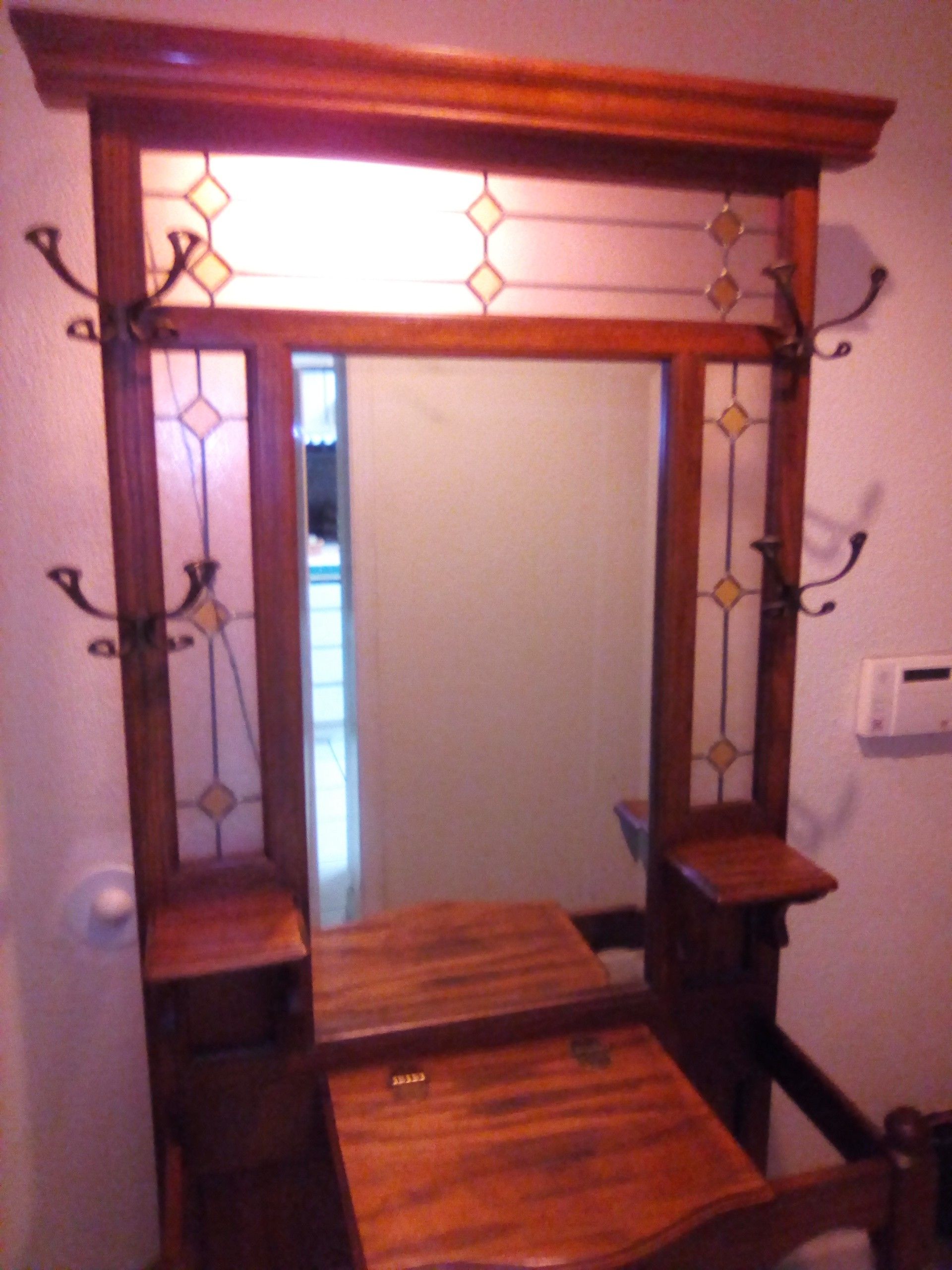Beautiful solid one piece Oak Hall Tree, Coat Hooks, Stained Glass, Mirror, Lights Up, Umbrella Stands on sides.