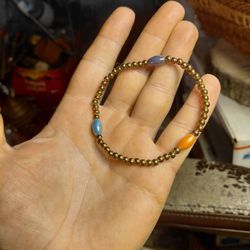 beaded stretch bracelet featuring small, metallic brown beads and larger, oval-shaped