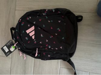 New Adidas backpack with a black base and a multi-colored logo pattern. This bag has pink, teal, and white accents throughout the design. It includes 