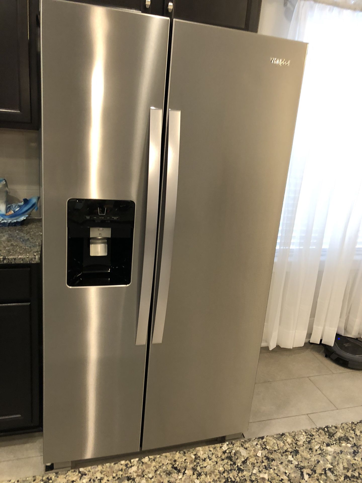 Stainless Whirlpool Side by Side Refrigerator with in door water and ice maker.