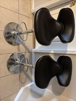 Two black leather adjustable bar stools