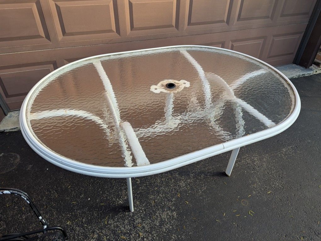 White oval patio table with glass top