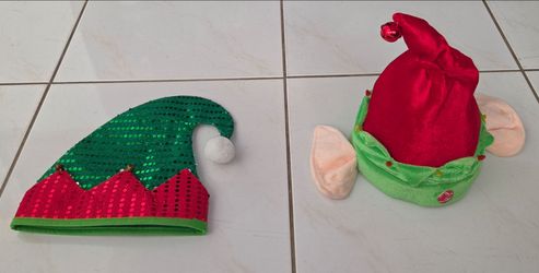 Set of 2 Christmas elf costume hats. One sequin elf hat with jingle bells and pom‑pom, one plush elf hat with elf ears. One hat is 9" diameter, 12" ta