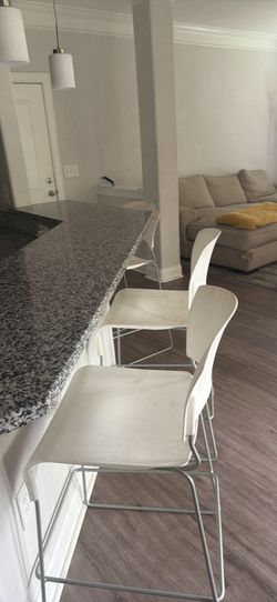 Three white bar stools