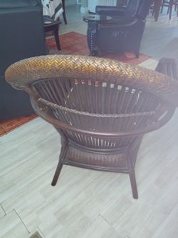 Rattan chair includes upholstered pad