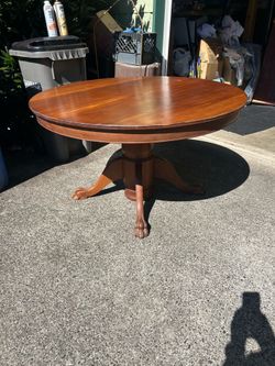 Antique wooden round table in good condition. Probably oak is my guess.  Measures 48 inches in diameter and 27 inches tall roughly.  Also, the legs ar