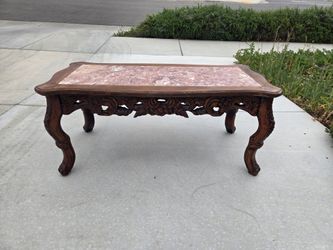 Vintage ornate carved coffee table with marble-style top and solid wood frame.