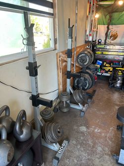 Squat Rack with Barbell, Weight Plates (535lbs worth of weights) and bench.