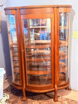 ANTIQUE EMPIRE BENT GLASS TIGER OAK CHINA CABINET WITH BALL & CLAW FEET
