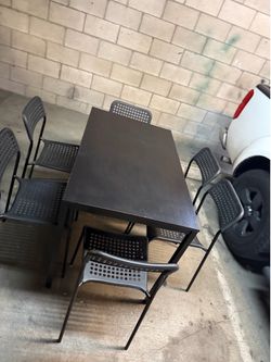 Black dining table with 6 chairs table has a metal frame