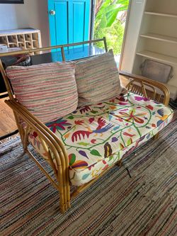 vintage mid-century natural bamboo and rattan loveseat featuring a colorful floral and bird-pattern