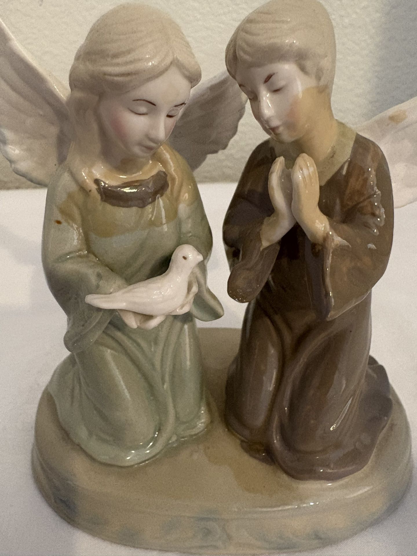 vintage porcelain figurine featuring two kneeling figures, often identified as angels or children