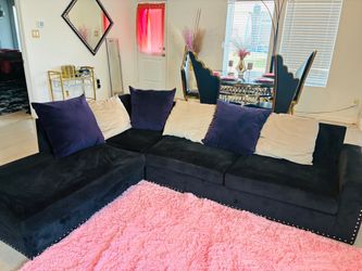 Black Sectional with purple and black pillows
