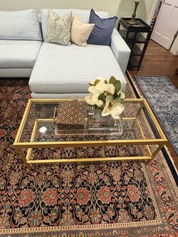 Modern elegant, gold metal and glass coffee table with two shelves