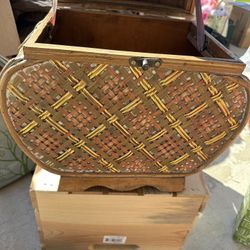 This appears to be a vintage handwoven bamboo and wicker storage box, possibly a liquor or wine carrying case, with brass edges and a metal latch. 