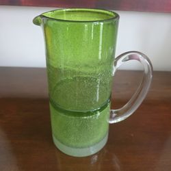 Hand-blown Blenko apple green glass pitcher with bubble inclusions and banded design.