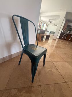 Stackable metal dining chairs in distressed green/blue