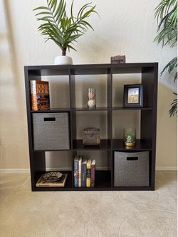 Dark brown 9 cubicle shelf 44” x 44” each cube opening is 13.5” x 13.5” with 2 gray woven storage cubes