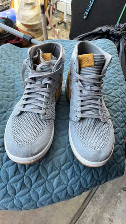 One pair of Nike light gray with yellow Nike emblem