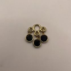 Gold tone charm with 3 black gems