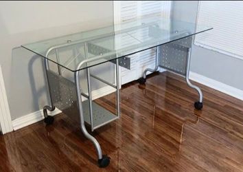 Glass-top computer/utility desk
Silver-tone metal/aluminum frame with metal side panels and lower storage shelf.
Caster wheels to move around easily