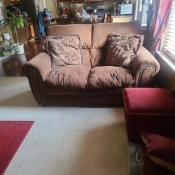 Chocolate loveseat and sofa with pillows