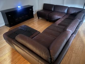 Genuine Italian leather sectional and TV stand with fire place.