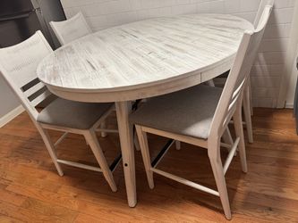 White grey white washed round table with four dining room chairs